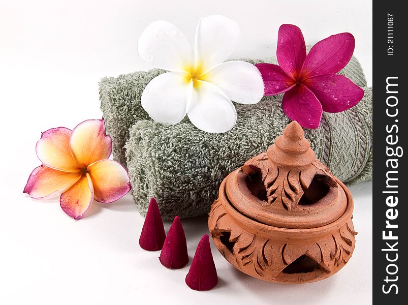 Spa accessories: Rolled towel, pampering stuff and frangipani flowers. Spa accessories: Rolled towel, pampering stuff and frangipani flowers.