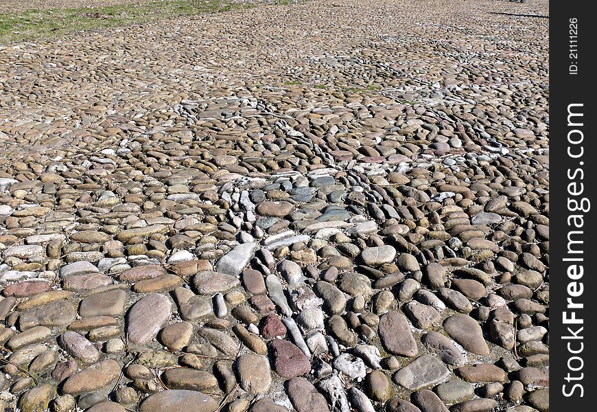 Texture of a pebble sidewalk in sunny day