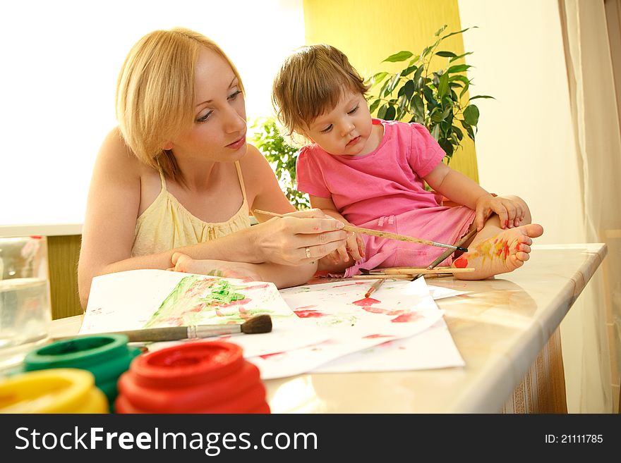 Mother drawing a flower on her daughter heel. Mother drawing a flower on her daughter heel