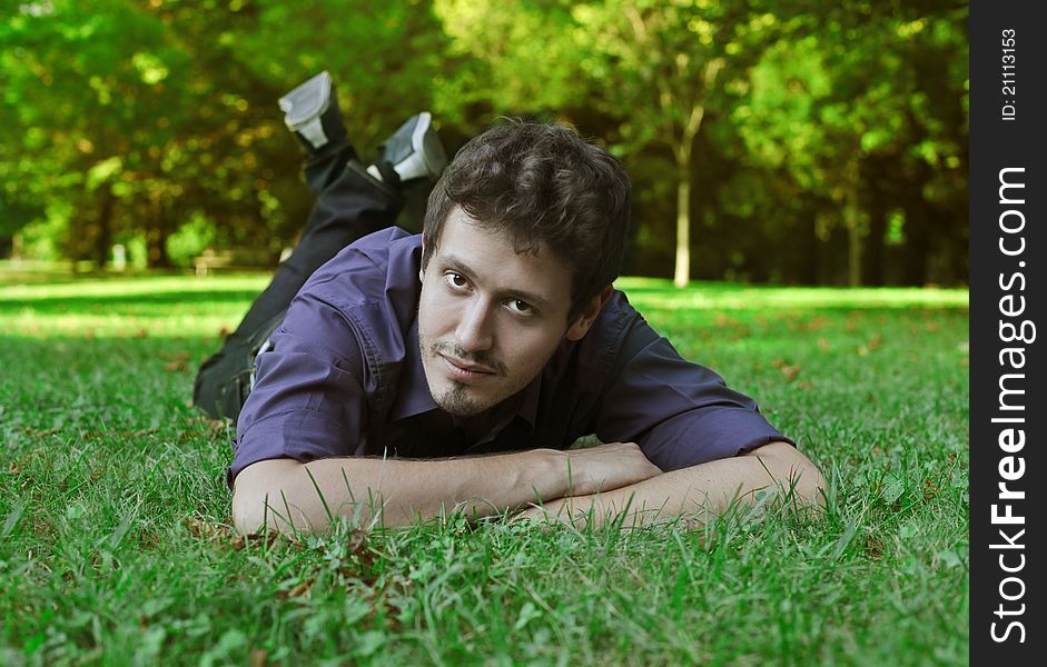 Handsome young man lying on a green meadow. Handsome young man lying on a green meadow