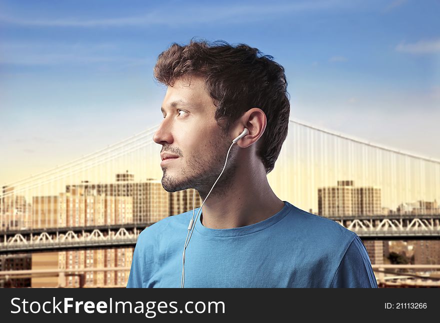 Young man listening to music with cityscape in the background. Young man listening to music with cityscape in the background