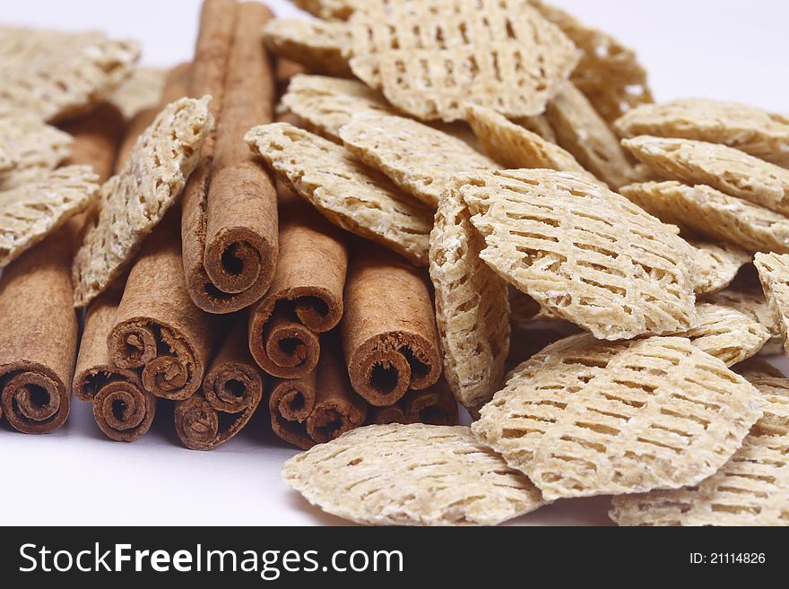 Cinnamon sticks and cereal on white background