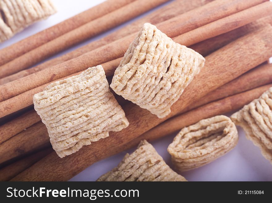 Cinnamon sticks and cereal on white background