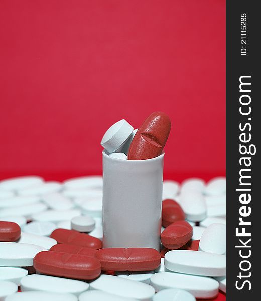 Red and white pills on red background