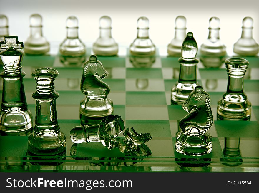 A glass chess board where one of the pieces is smashed. A glass chess board where one of the pieces is smashed