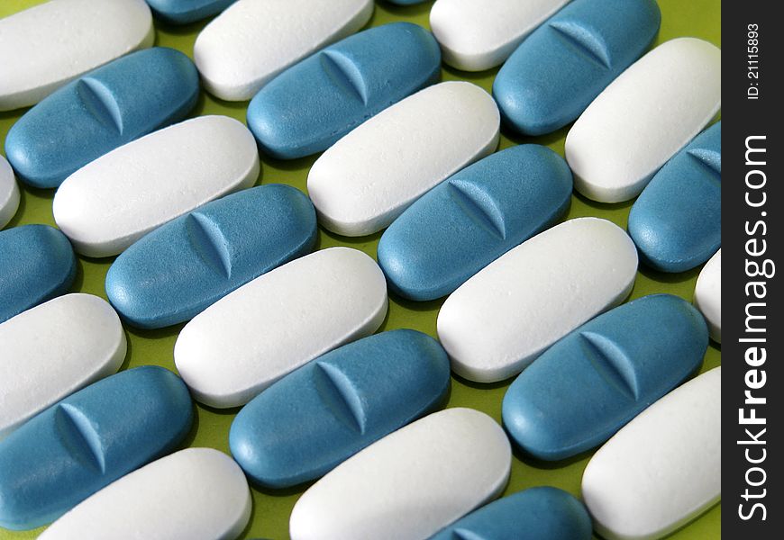 Many white and blue pills on blue background