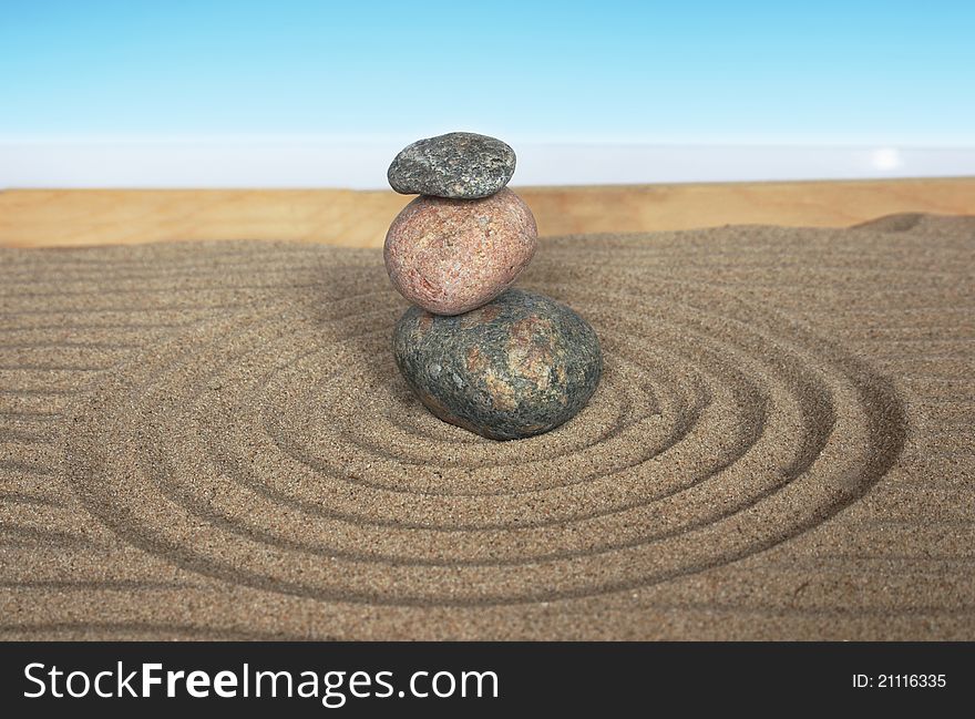 Pyramid with three stones on a sand background
