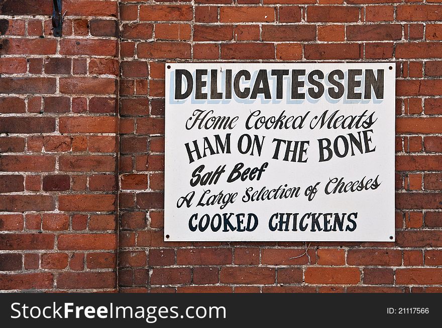 Old fashioned sign written shops sign on a red brick wall. Old fashioned sign written shops sign on a red brick wall