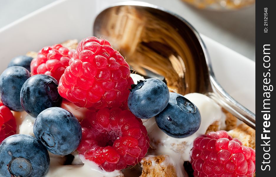 Breakfast Cereal with Blueberries and Raspberries eith milk in close-up