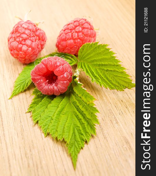 Fresh raspberries with leaves on the table