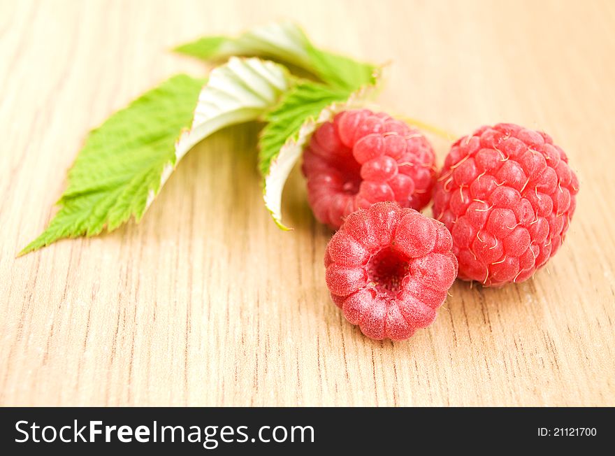 Fresh raspberries with leaves on the table