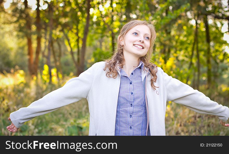 Young beautiful Girl with arms outstretched enjoying at the park. Young beautiful Girl with arms outstretched enjoying at the park