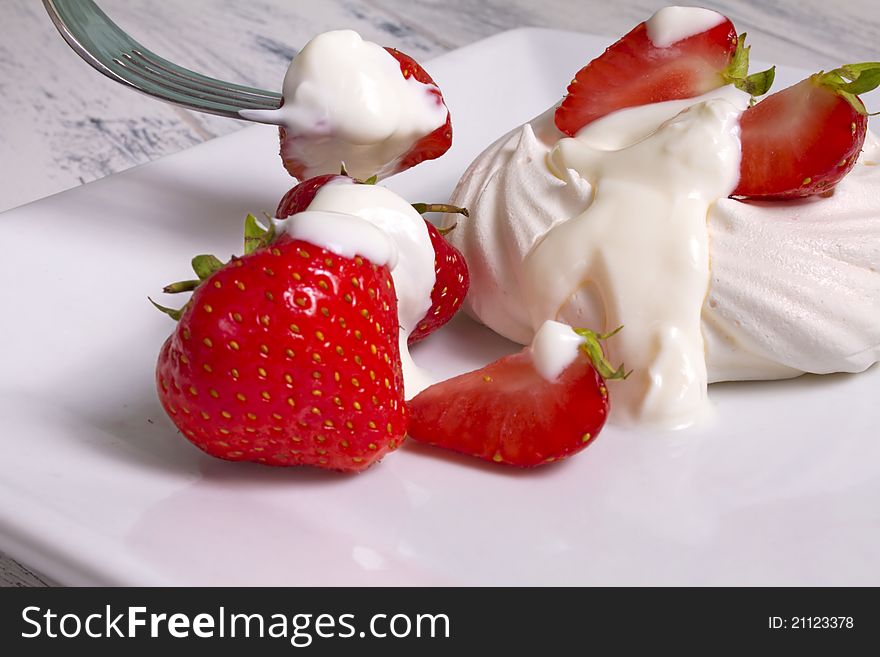 Strawberries, Meringue and cream on a white plate