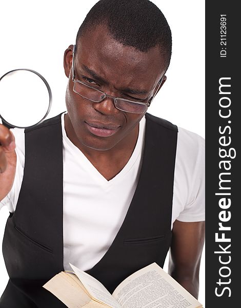Young and beautiful black man holding a magnifying glass and reading a book