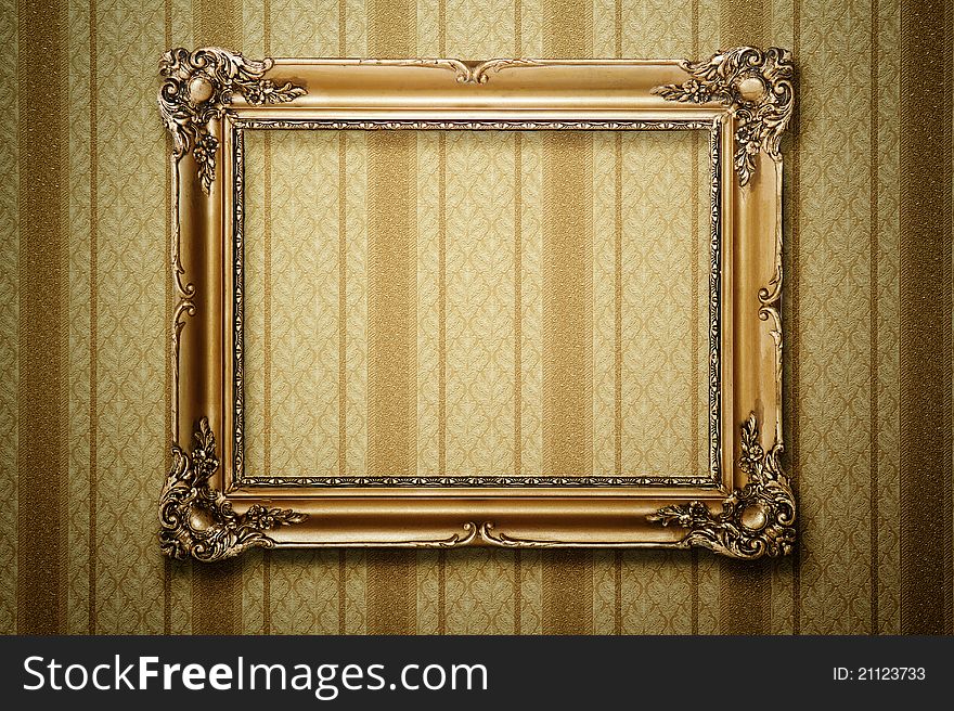 Grunge gold wooden frame on striped wallpaper with clipping path. Grunge gold wooden frame on striped wallpaper with clipping path