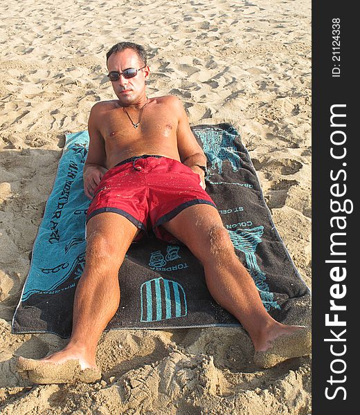 Boy lying on the towel sunbathing on the beach. Boy lying on the towel sunbathing on the beach