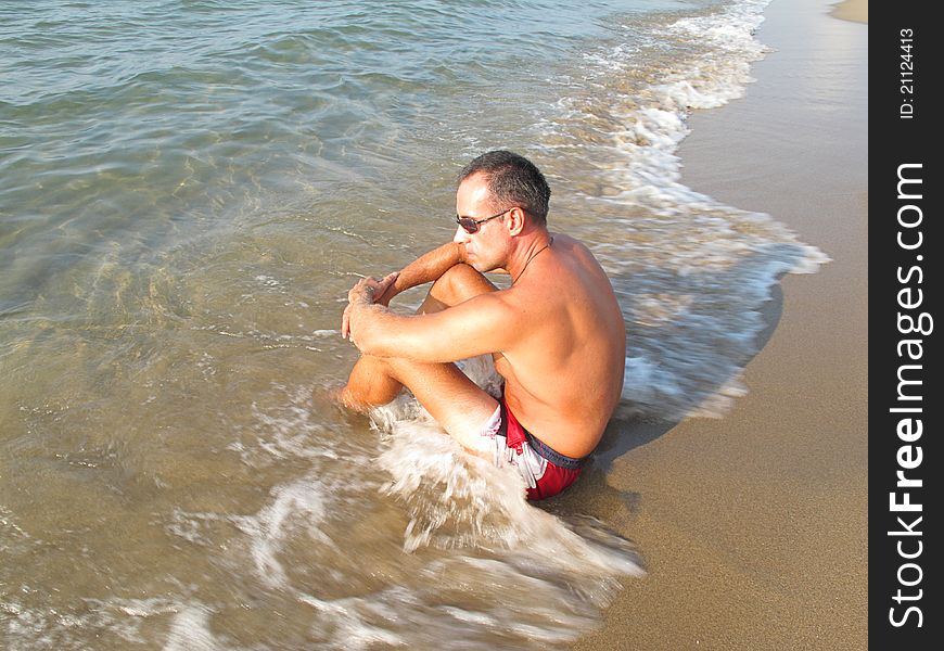 Boy sitting on the edge of the beach. Boy sitting on the edge of the beach