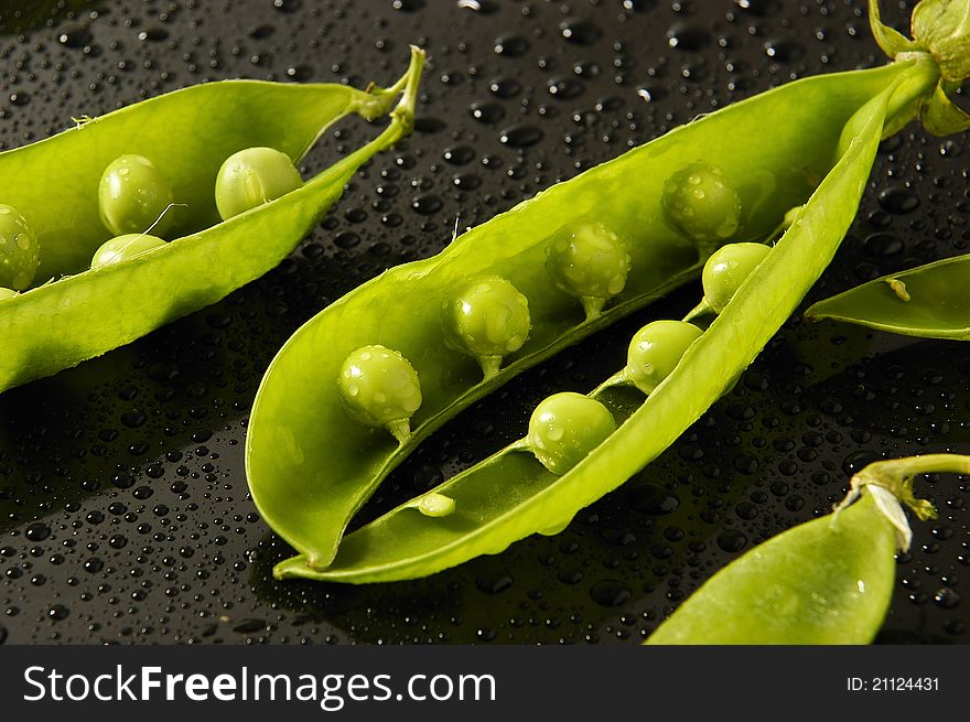 Green peas in the pod with water droplets