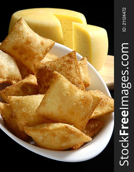 Breaded fried cheese on white plate with black background