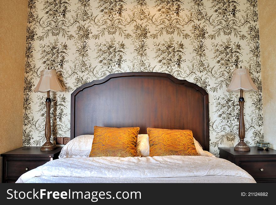 Bedroom flowery wall paper and wooden furniture