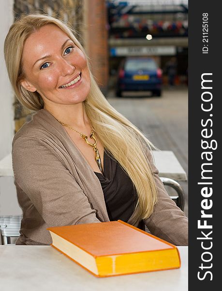 Happy woman sitting with a book.