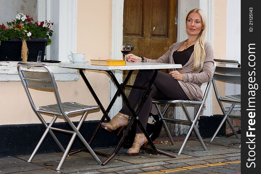 A young woman enjoying a drink outdoors. A young woman enjoying a drink outdoors.