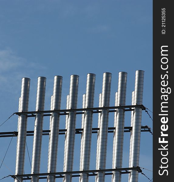 Vertical steel pipes with blue sky in background. Vertical steel pipes with blue sky in background