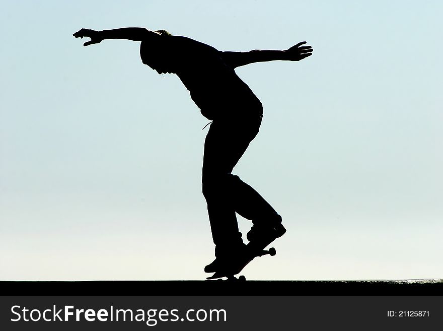 Male skateboarder jumps on a concrete edge at a skateboard park