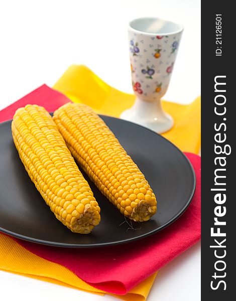 Cooked corn on black plate