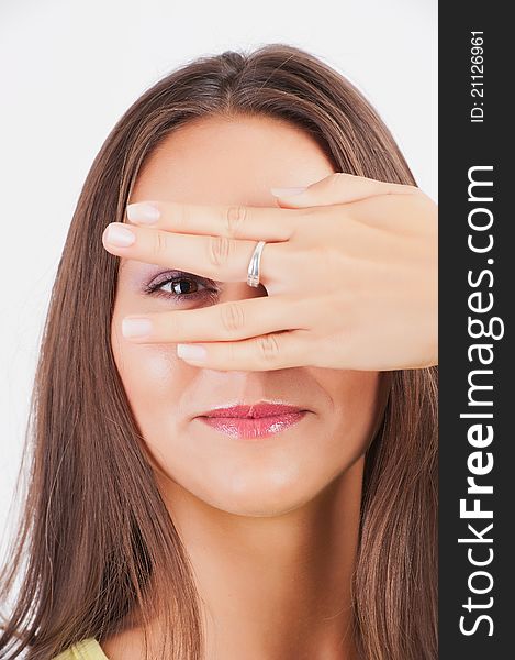 Closeup portrait of charming young woman peeking though her fingers