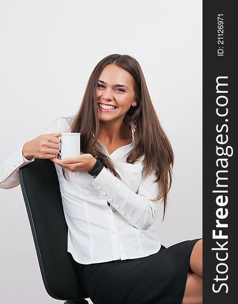 Gorgeous young woman giving you warm smile while drinking tea