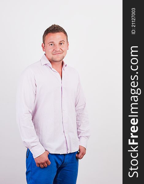 Portrait of good looking young man smiling over white background with hand on hips