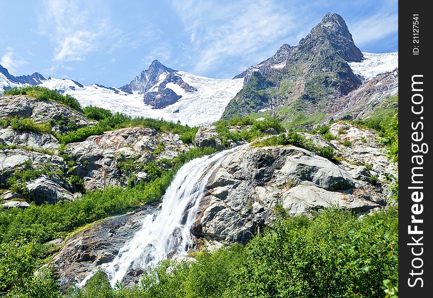 Huge waterfall among the rocky mountains covered with snow. Huge waterfall among the rocky mountains covered with snow