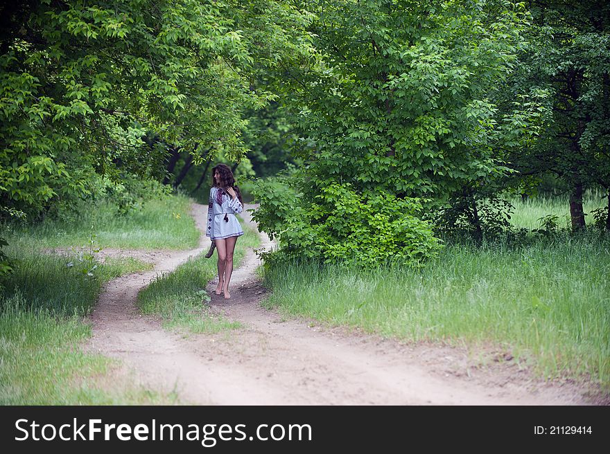 Portrait of a slender young woman with long hair dressed in beautiful national, walks on forest. Portrait of a slender young woman with long hair dressed in beautiful national, walks on forest