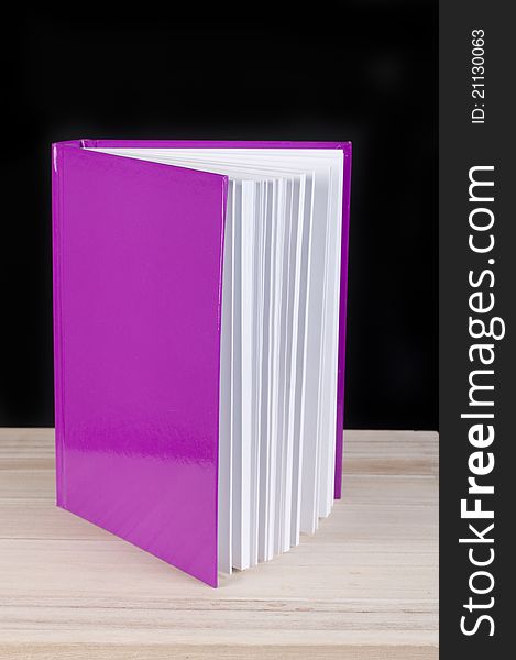 Pink book on a black studio background. Pink book on a black studio background