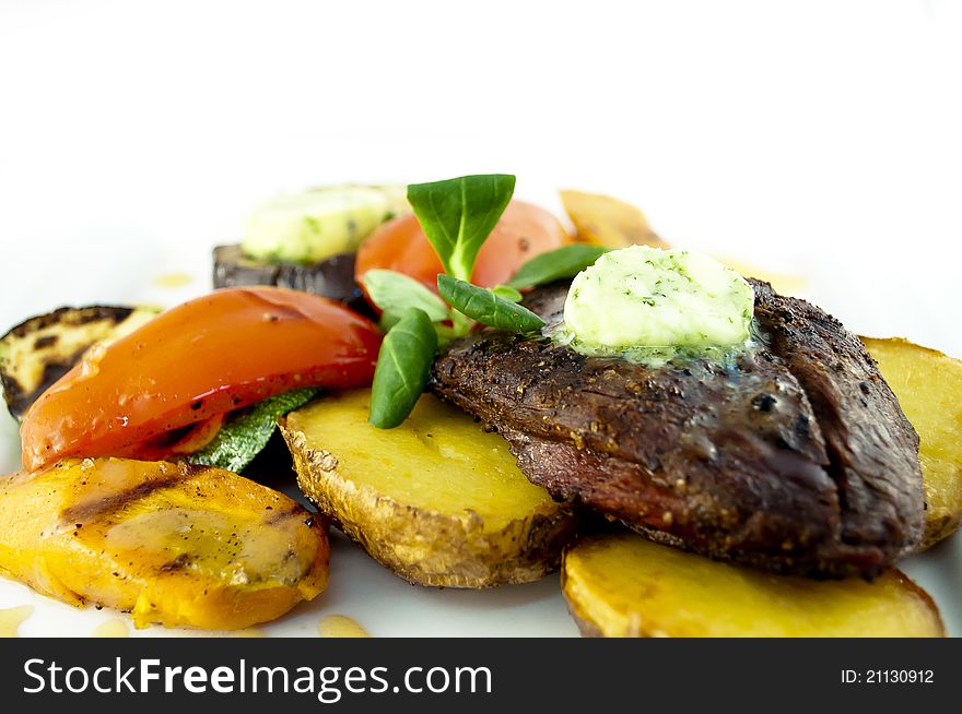 Beef steak with pesto butter in white plate.