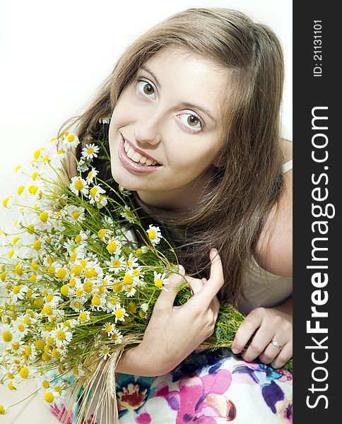 Happy young smiling girl with camomile against white background. Happy young smiling girl with camomile against white background