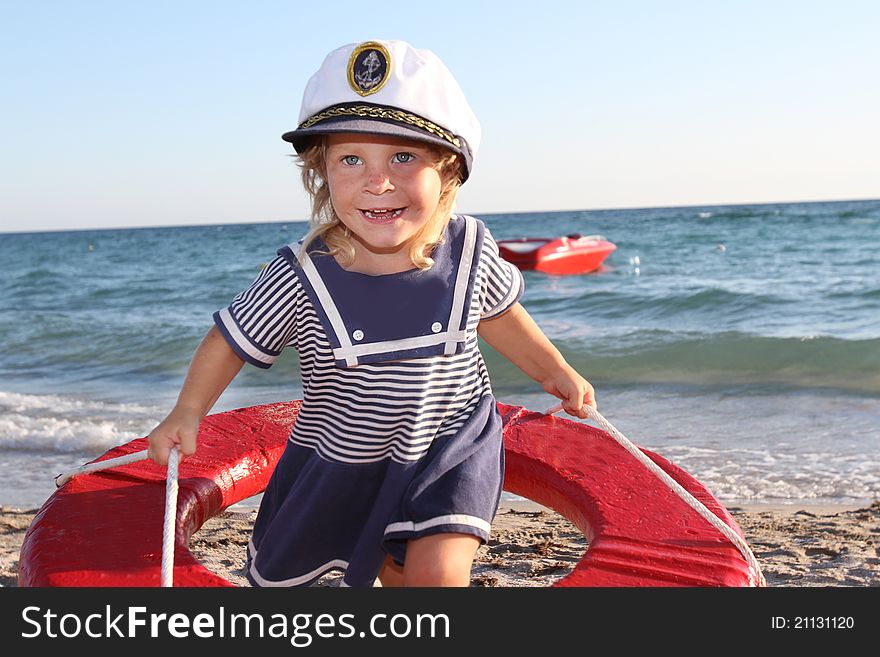 Happy girl in sailor hat on beach