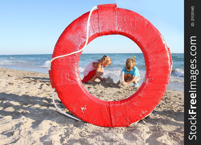 Children playing on beach, view through lifesaver