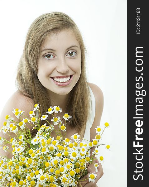 Happy young smiling brunette with daisy against light background. Happy young smiling brunette with daisy against light background