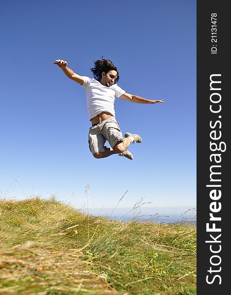 Young male jumping for joy on top of the mountain. Young male jumping for joy on top of the mountain.