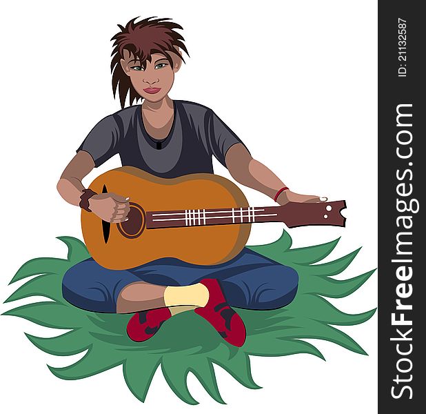 Boy plays guitar sitting on the grass