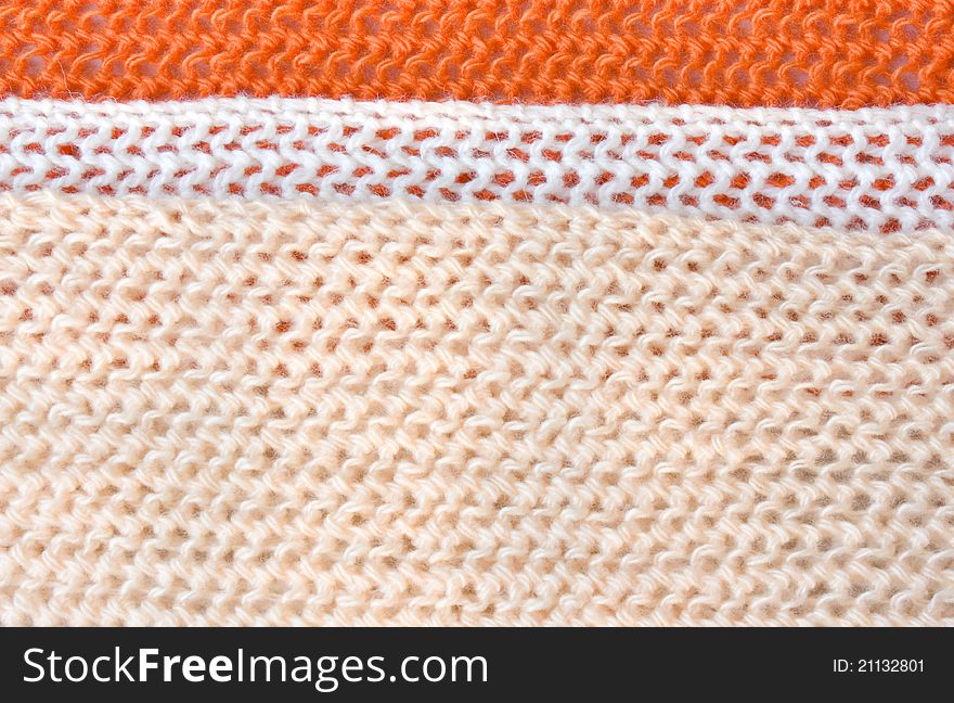 Three strip (orange, white, beige) of knitted fabric close up. Three strip (orange, white, beige) of knitted fabric close up.
