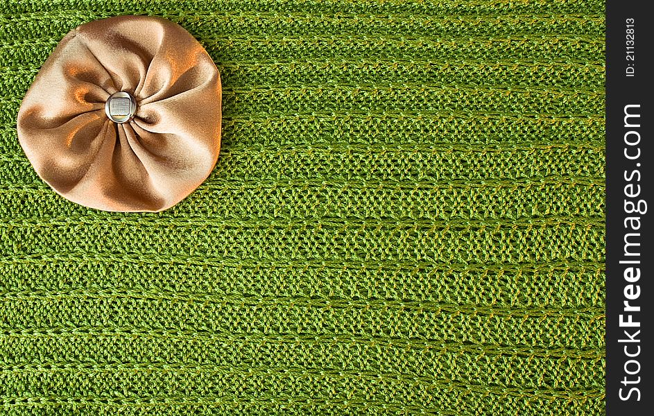 Brown with gold bow lies on the sparkling green knit fabric. Brown with gold bow lies on the sparkling green knit fabric.