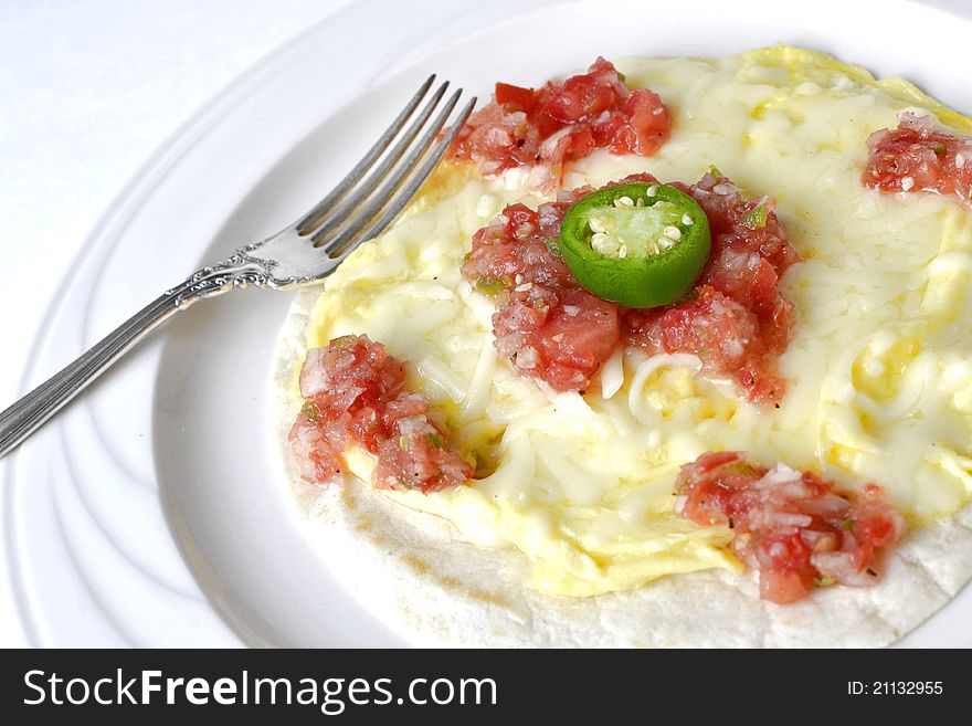 Fresh eggs scrambled on tortilla with tomato salsa and pepper. Fresh eggs scrambled on tortilla with tomato salsa and pepper.