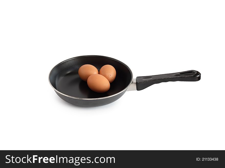 Three raw chicken eggs lying on frying pan. Isolated on white with clipping path. Three raw chicken eggs lying on frying pan. Isolated on white with clipping path