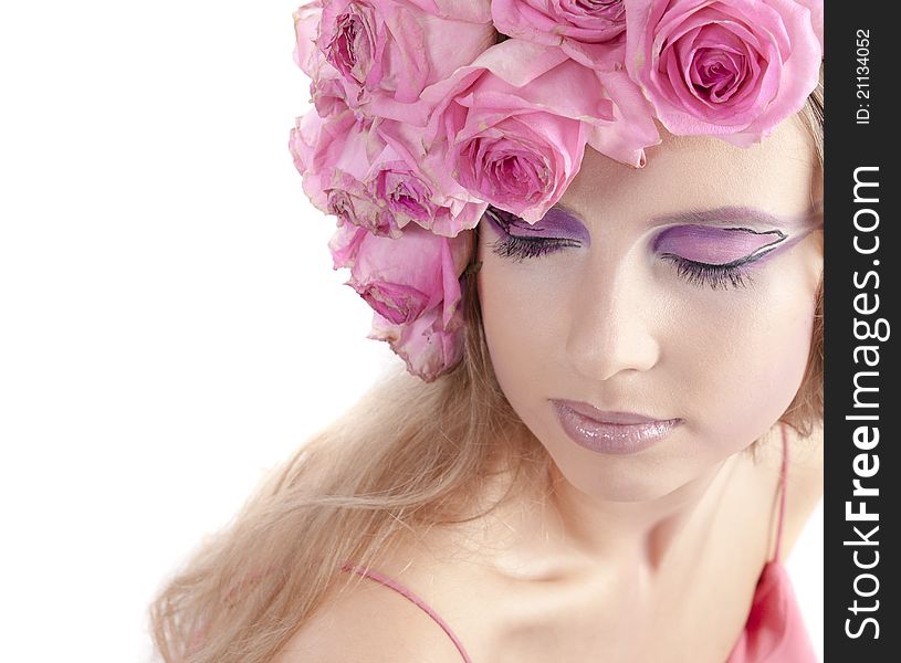 Young beautiful woman with pink flowers on her head over white