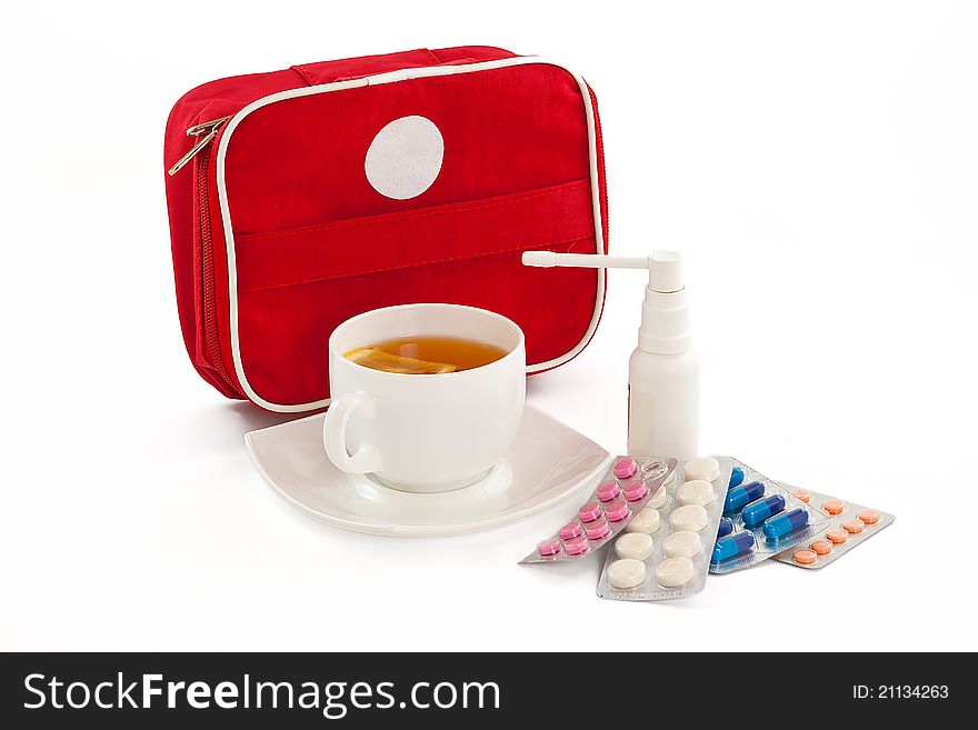 The image of the first-aid set, cup of tea with a lemon, tablets and an inhaler. The image of the first-aid set, cup of tea with a lemon, tablets and an inhaler