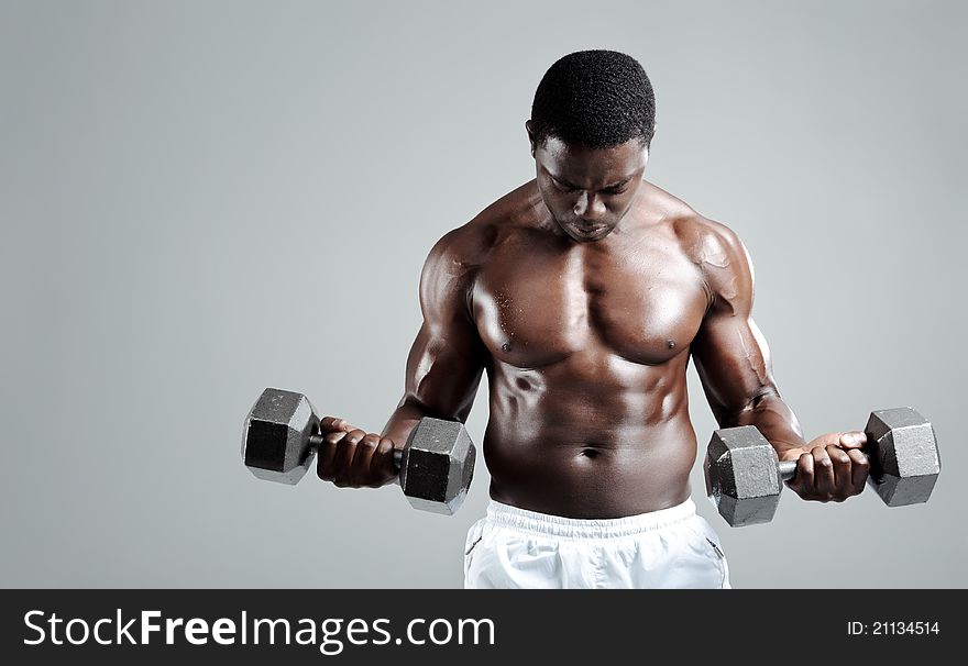 Well built muscular black man pumping iron. Well built muscular black man pumping iron