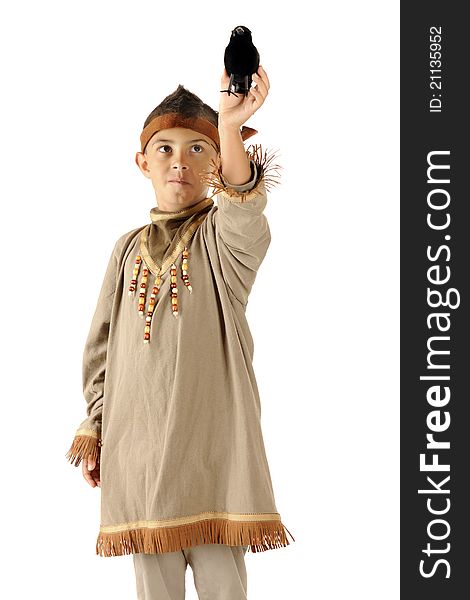 An elemantary boy dressed as a native American Indian holding aa big lack bird up to take off from his hand. An elemantary boy dressed as a native American Indian holding aa big lack bird up to take off from his hand.